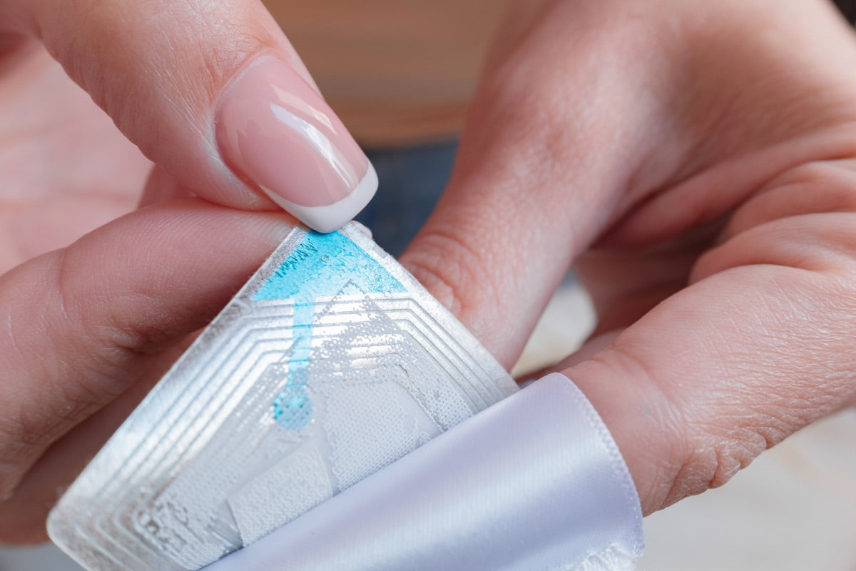 Close-up of an RFID inlay antenna being applied to a label
